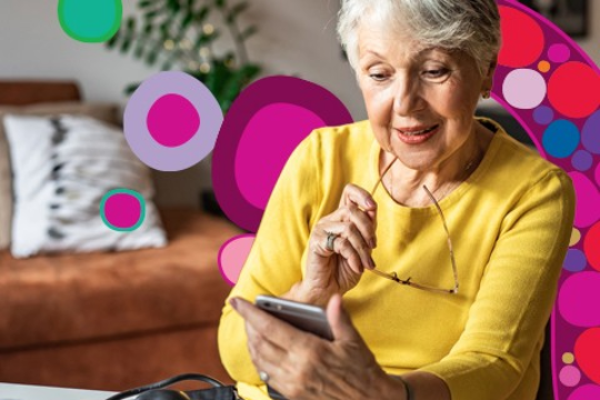 older woman looking at phone while holding glasses