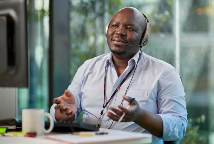 man sitting at desk with headset