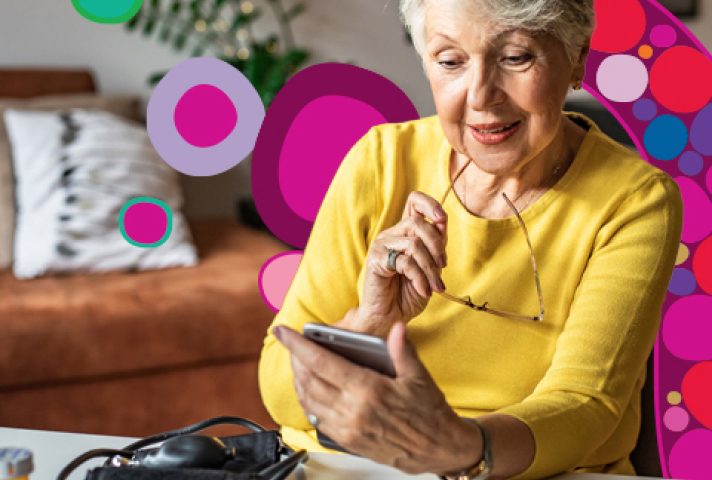 older lady sitting at desk looking at phone
